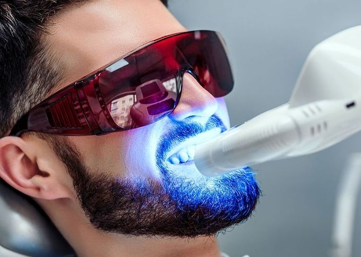 Mann mit einer UV Lampe vor dem Gesicht